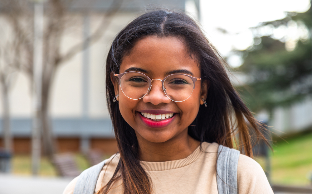 Headshot of happy young african american female college student looking at camera. Education and gen z concept.